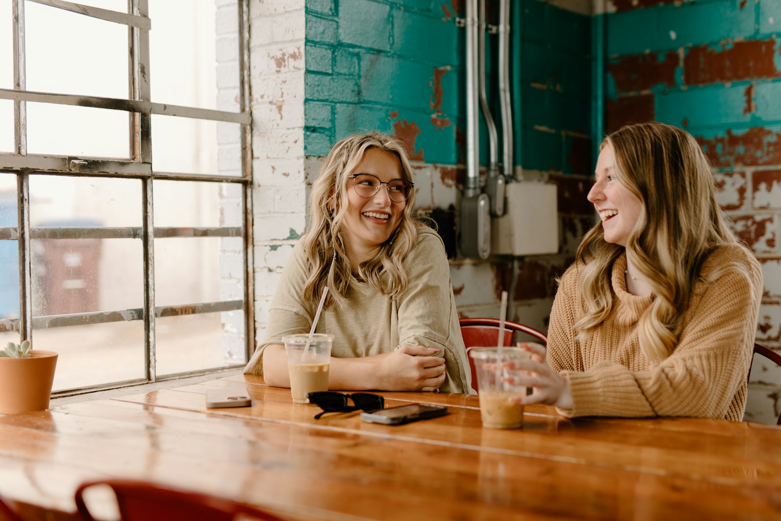 a couple of women sitting at a wooden table